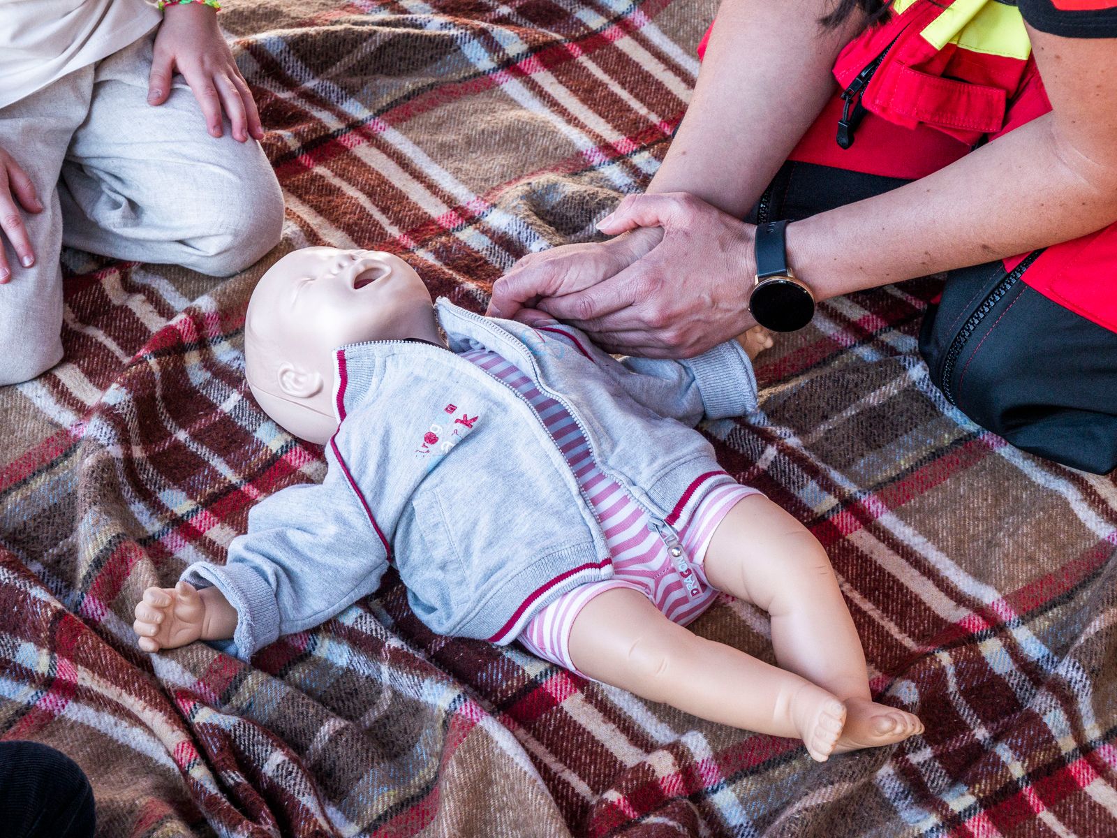 Trainer demonstrating CPR on a baby mannequin during a paediatric first aid course